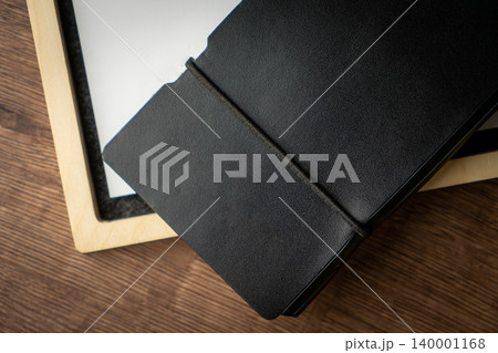 Handmade black wallet made of genuine leather on a wooden background. Close-up, top view. 140001168