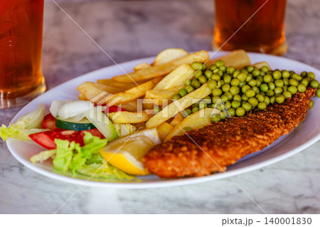 Delicious fish and chips served with peas, salad 140001830