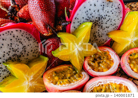 Colorful display of tropical fruits including dragon fruit, passion fruit, and star fruit Colorful display of tropical fruits including dragon fruit, passion fruit, and star fruit 140001871