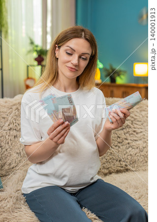 Pregnant woman counts UAH Ukrainian hryvnia cash planning baby birth budget money preparation 140001913