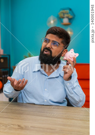 Indian man shakes empty piggy bank disappointed debt bankruptcy shows frustration big financial loss 140001948