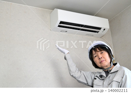 エアコンの点検をする女性作業員イメージ 140002211