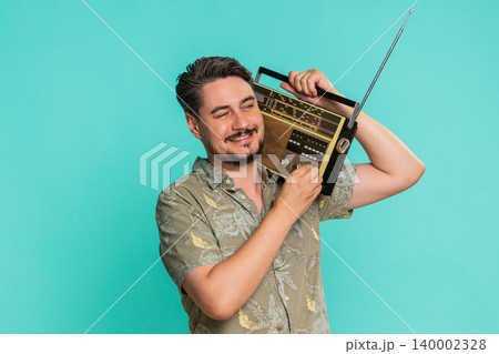 Man holds vintage cassette player on shoulder dancing energetically enjoying retro music experience Man holds vintage cassette player on shoulder dancing energetically enjoying retro music experience 140002328
