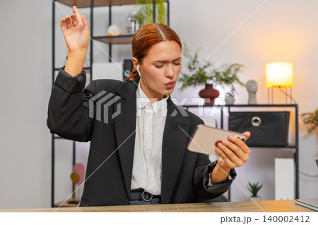 Young businesswoman dances with wireless headphones watching smartphone video enjoying beat rhythm Young businesswoman dances with wireless headphones watching smartphone video enjoying beat rhythm 140002412
