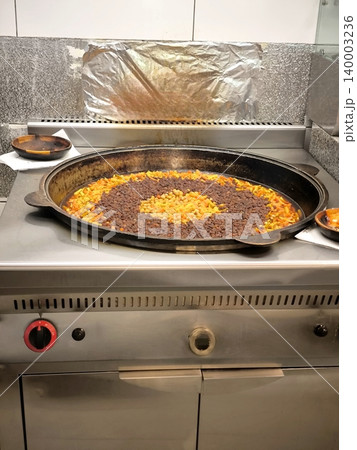 Traditional Uzbek pilaf being prepared in a large cauldron. Traditional Uzbek pilaf being prepared in a large cauldron. 140003236