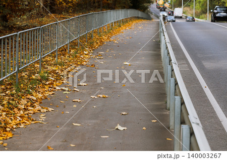 sidewalk of driving car road asphalt way perspective view Autumn leaves along passing cars sidewalk of driving car road asphalt way perspective view Autumn leaves along passing cars 140003267