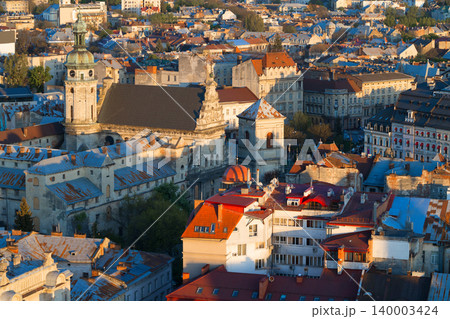 Drone view of historic European city rooftops bathed in golden hour sunlight Drone view of historic European city rooftops bathed in golden hour sunlight 140003424