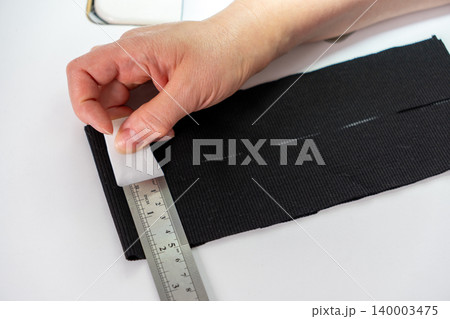Close up of measuring and marking fabric for tailoring Close up of measuring and marking fabric for tailoring 140003475