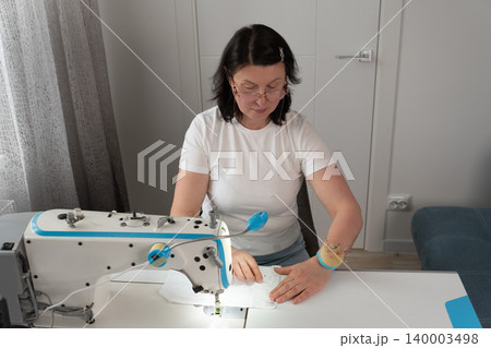 Close up of woman pinning fabric during tailoring process Close up of woman pinning fabric during tailoring process 140003498