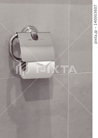 White toilet paper in holder. WC design. white soft toilet paper on grey background. Sanitary concept. Private hygiene concept. Public restroom indoors. Domestic bathroom decor. White toilet paper in holder. WC design. white soft toilet paper on grey background. Sanitary concept. Private hygiene concept. Public restroom indoors. Domestic bathroom decor. 140003607