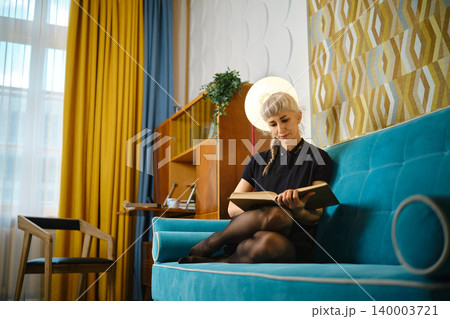 Reading quietly in colorful room with modern design and warm light during afternoon Reading quietly in colorful room with modern design and warm light during afternoon 140003721