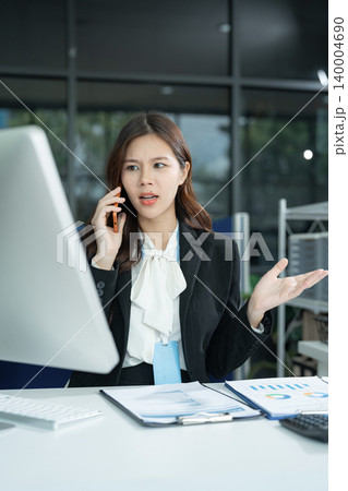 Businesswoman talking on the phone arguing laptop computer problems highlighting customer dissatisfaction. Businesswoman talking on the phone arguing laptop computer problems highlighting customer dissatisfaction. 140004690