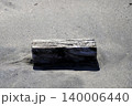 砂浜に流れ着いた枕木のような四角い流木 140006440