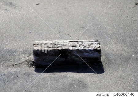 砂浜に流れ着いた枕木のような四角い流木 140006440