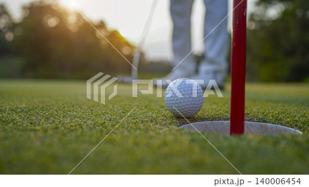 Golfers are putting golf in the evening golf course golf backglound. Golfers are putting golf in the evening golf course golf backglound. 140006454