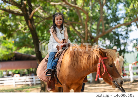 happy toddler girl riding the brown horse happy toddler girl riding the brown horse 140006505