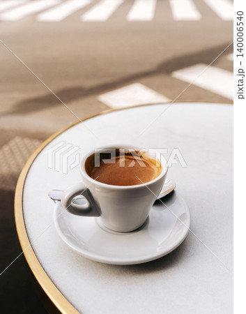 Fresh espresso in a white cup on a minimalist cafe table, bathed in soft natural light Fresh espresso in a white cup on a minimalist cafe table, bathed in soft natural light 140006540