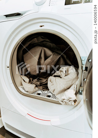 Open washing machine with a load of clothes Open washing machine with a load of clothes 140006594