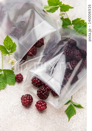 Frozen blackberries spilling from vacuum seal bags Frozen blackberries spilling from vacuum seal bags 140006916