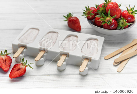 Homemade strawberry yogurt popsicles in mold with fruit Homemade strawberry yogurt popsicles in mold with fruit 140006920