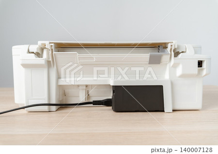 White Multifunction Printer With Ink Tank And Power Cable On Desktop Office Workspace 140007128