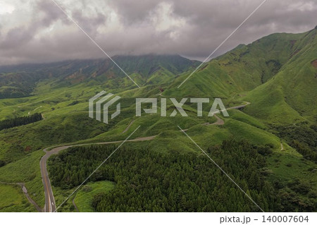 熊本県南阿蘇の緑の高原と蛇行する山岳道路を捉えた空撮写真 熊本県南阿蘇の緑の高原と蛇行する山岳道路を捉えた空撮写真 140007604