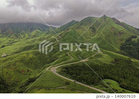 熊本県南阿蘇の緑の山々を縫うワインディングロードの空撮写真 熊本県南阿蘇の緑の山々を縫うワインディングロードの空撮写真 140007610