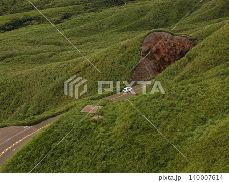 熊本県南阿蘇の緑の火山丘陵を走る山岳道路の空撮写真 熊本県南阿蘇の緑の火山丘陵を走る山岳道路の空撮写真 140007614