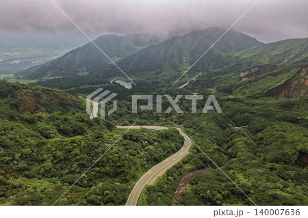 熊本県南阿蘇の緑豊かな山間を縫う曲がりくねった道路の空撮写真 熊本県南阿蘇の緑豊かな山間を縫う曲がりくねった道路の空撮写真 140007636