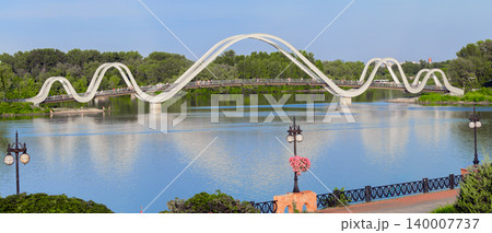 waterfront city landscaped design walking side district along river and modern wavy bridge architectural object in spring blossom season waterfront city landscaped design walking side district along river and modern wavy bridge architectural object in spring blossom season 140007737