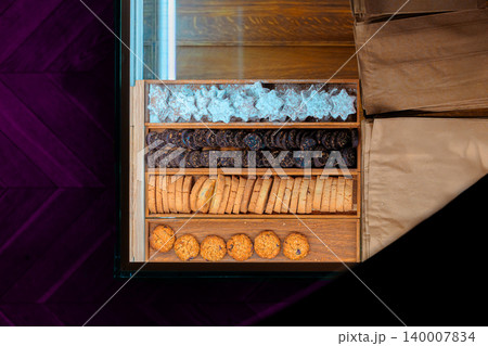 cookies baked food counter square pattern top view inside bakery shop cafe yellow purple contrast warm lighting 140007834