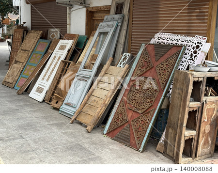 Vintage wooden doors displayed outside antique shop with intricate designs and weathered textures Vintage wooden doors displayed outside antique shop with intricate designs and weathered textures 140008088