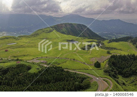 熊本県南阿蘇の緑の草原と火山丘・曲がりくねった道路を捉えた空撮写真 熊本県南阿蘇の緑の草原と火山丘・曲がりくねった道路を捉えた空撮写真 140008546