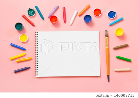 Back to school. Colorful wax crayons and album on pink. 140008713
