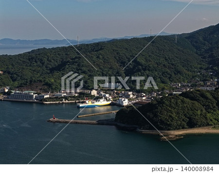 大分県佐賀関の港に停泊するフェリーと海岸集落を俯瞰した空撮写真 140008984