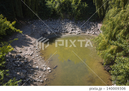 Dry riverbed showing drought conditions with low water 140009306