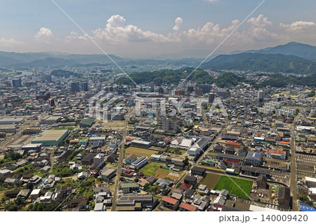 宮崎県延岡市の市街地と山並みを捉えた空撮写真 140009420
