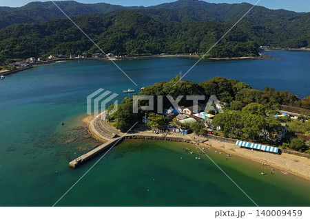 大分県臼杵市黒島の海水浴場と桟橋を俯瞰した空撮写真 140009459