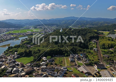 大分県臼杵市の市街地と白い塔が立つ丘を俯瞰した空撮写真 140009485