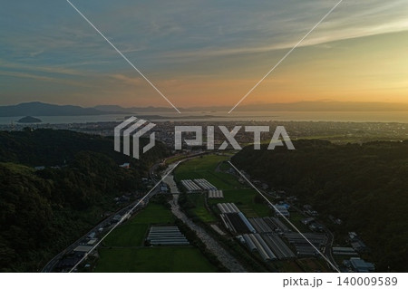 長崎県大村市・大村湾を望む農業ハウスと市街地の夕景空撮写真 140009589