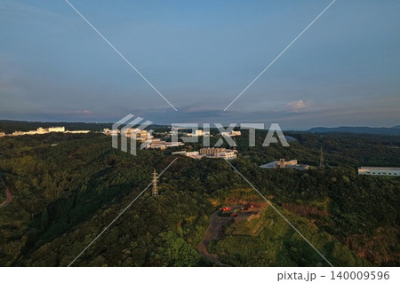 長崎県大村市の丘陵地帯と施設群を捉えた夕方の空撮写真 140009596