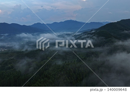熊本県山都市付近の霧に包まれた山岳森林の夕暮れ空撮写真 140009648