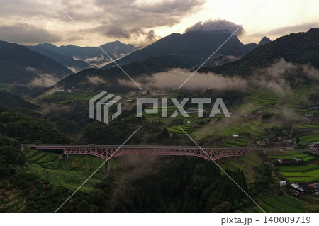宮崎県日之影町の霧立つ山間に架かる赤いアーチ橋を捉えた空撮写真 宮崎県日之影町の霧立つ山間に架かる赤いアーチ橋を捉えた空撮写真 140009719