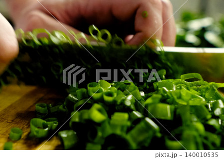 Shredded green onion with a knife. Greens Shredded green onion with a knife. Greens 140010535