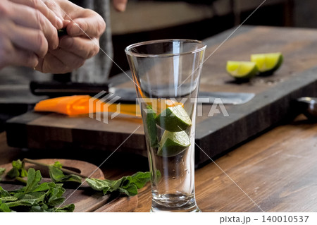 making cocktail of mint and lemon. making cocktail of mint and lemon. 140010537