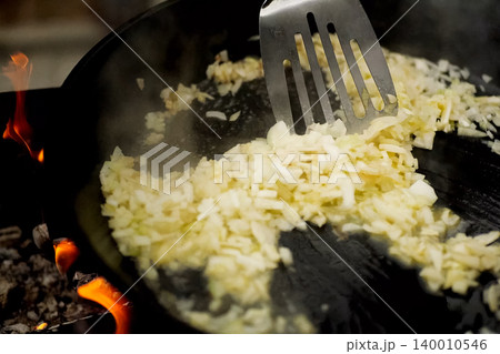 Roasting onions in pan with oil on fire. Roasting onions in pan with oil on fire. 140010546
