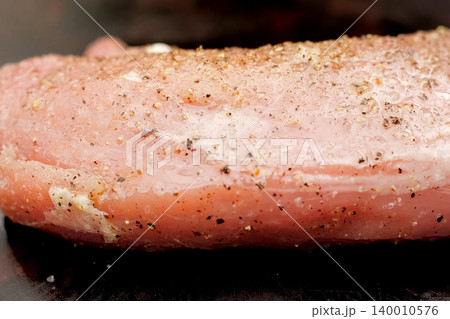 Raw meat sprinkled with seasonings. Start cooking 140010576