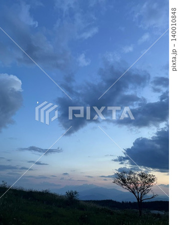 雲の上に浮かぶ月と夕焼けの景色 雲の上に浮かぶ月と夕焼けの景色 140010848