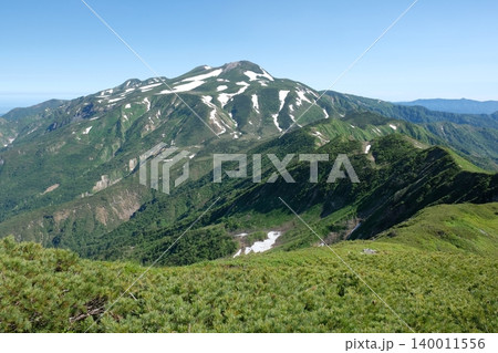 残雪と新緑が広がる稜線の爽やかな山の風景 140011556