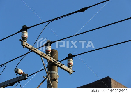 青空に映える電柱の高圧電線と白いがいし(碍子)のクローズアップ 青空に映える電柱の高圧電線と白いがいし(碍子)のクローズアップ 140012402